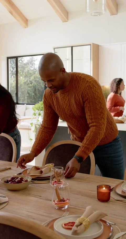 Vertical video: Preparing dinner, African American man arranging plates at Видео 346735375