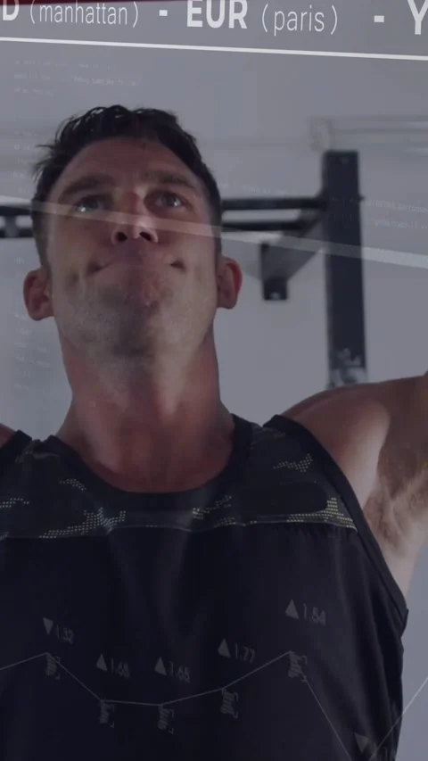 Vertical video: Preparing man in black tank doing pull-ups on red bar at gym Stock Footage 332317510