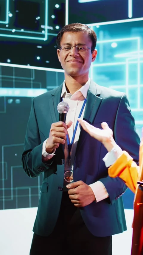 Vertical video Presenter and guest talking at AI summit exploring latest tech Stock Footage 278553575