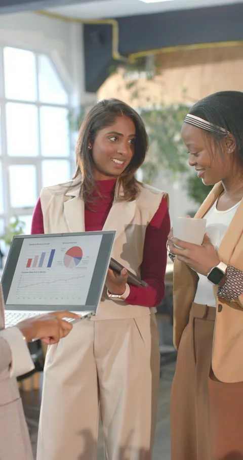 Vertical video: Presenter gesturing charts, Diverse female coworkers checking Stock Footage 345491686
