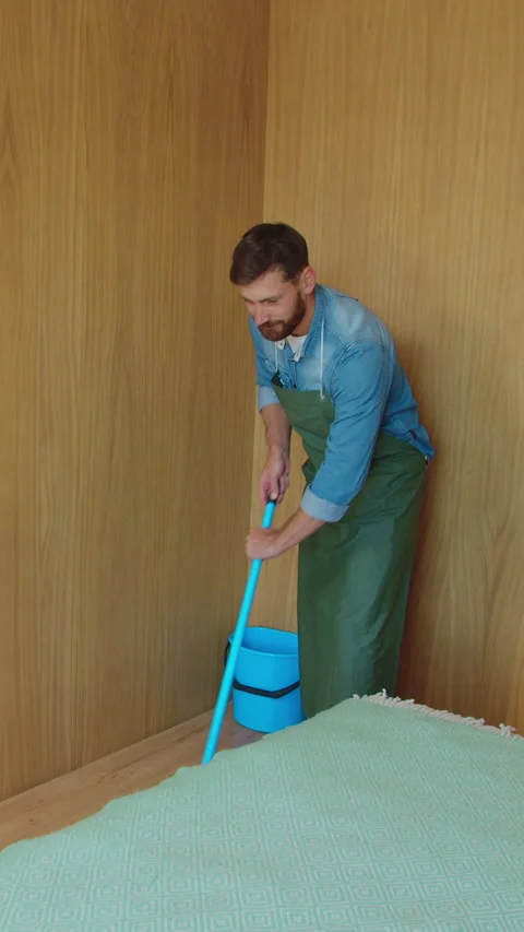 Vertical Video Professional cleaner in uniform washing floor in the hotel room Stock Footage 337995650