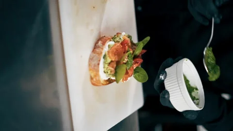 Vertical video in a professional kitchen chef in a black jacket decorates a Stock Footage 276873807