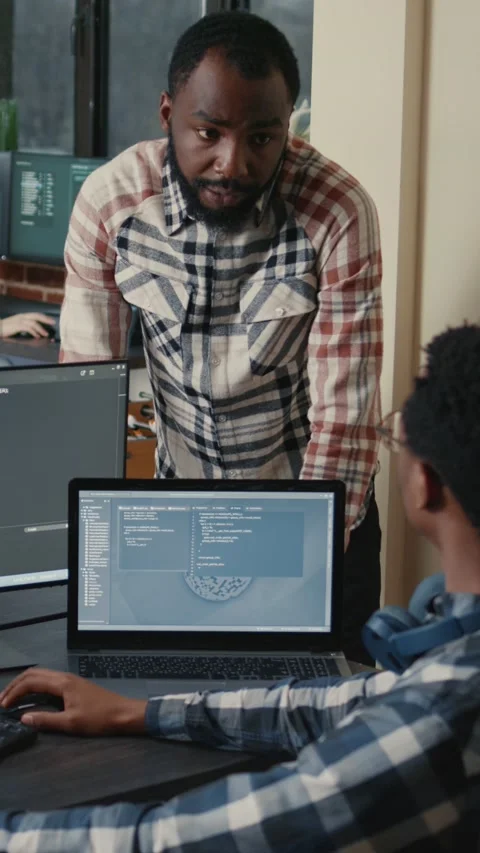 Vertical video Programer sitting at desk with multiple screens running code Stock Footage 201719943