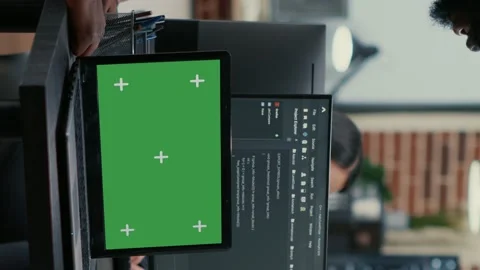 Vertical video Programer taking glasses off talking with colleague at desk with Stock Footage 194148846