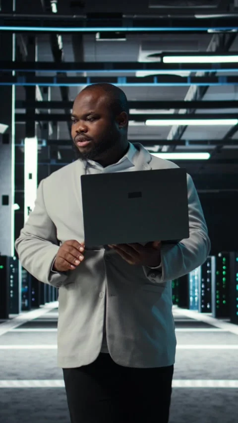 Vertical video Programmer in data center using laptop, testing equipment Stock Footage 311340343