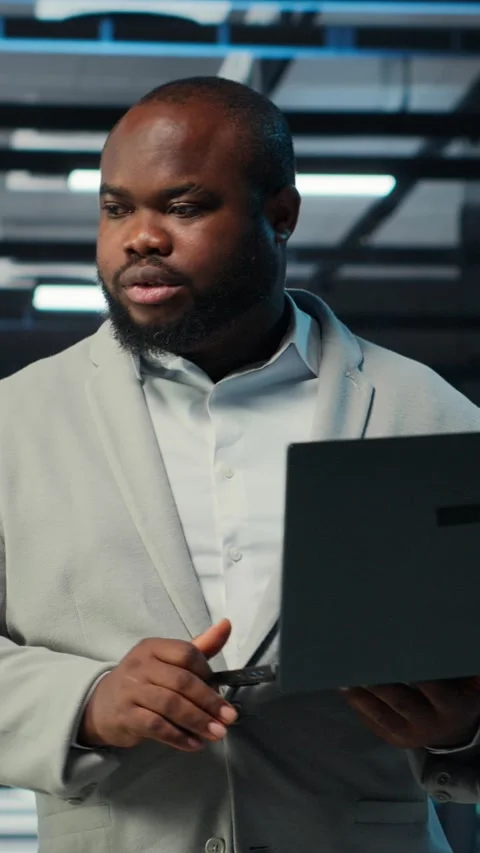 Vertical video Programmer in data center using laptop, testing equipment Stock Footage 311412875