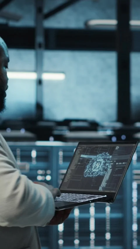Vertical video Programmer in data center using laptop, employing AI machine Stock-Footage 311413476