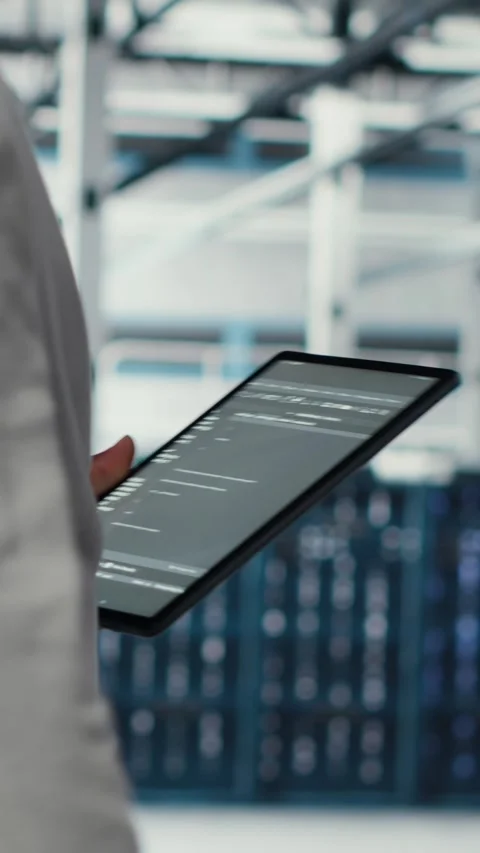 Vertical video Programmer in data center using tablet to manage software updates Stock-Footage 311548269