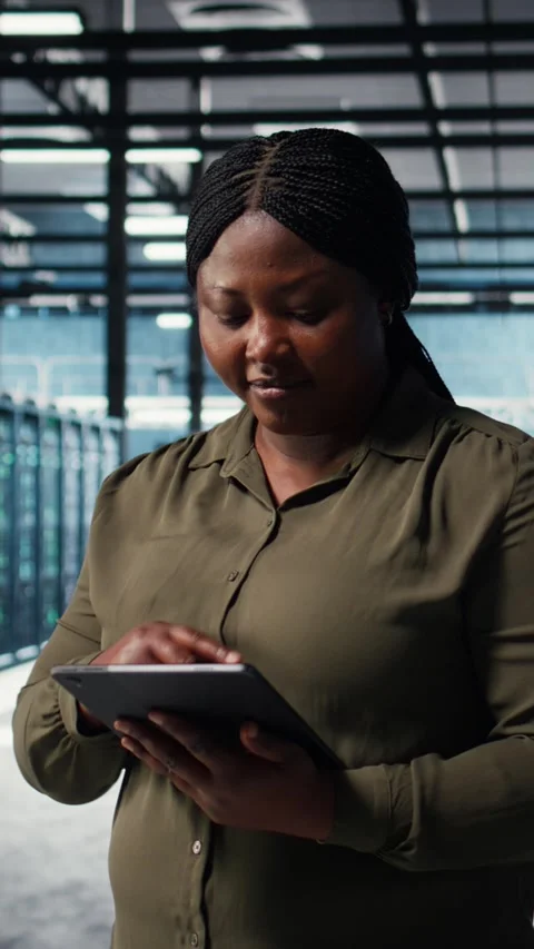 Vertical video Programmer in data center using tablet to increase workload Stock-Footage 316860901