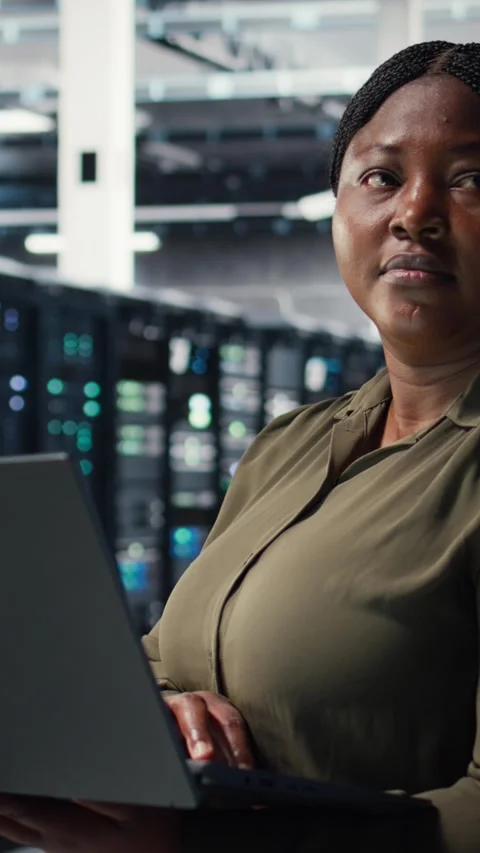 Vertical video Programmer in data center using laptop to deploy new server Stock-Footage 317054048