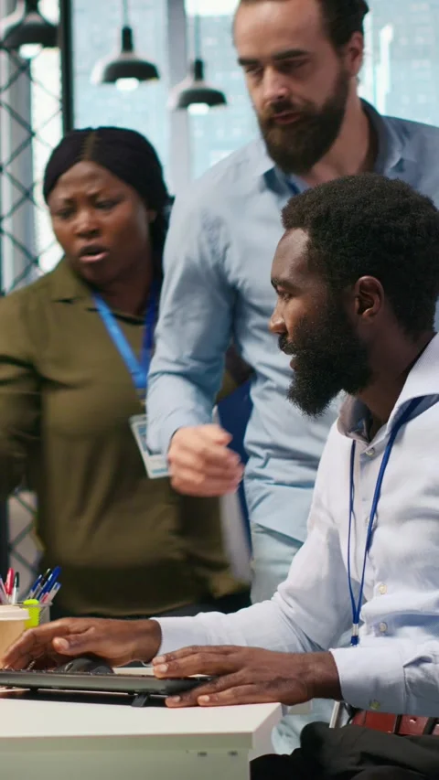 Vertical video Programmer in office requesting help from coworkers to fix Stock Footage 312709471