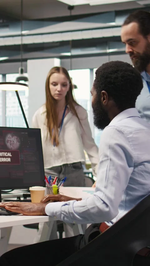 Vertical video Programmer in office requesting help from coworkers to fix Stock Footage 312709487