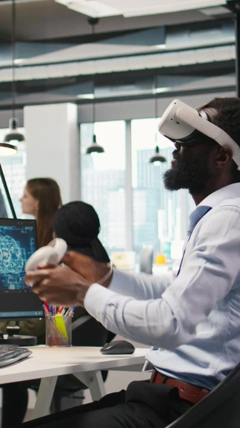 Vertical video Programmer wearing VR headset at office desk developing programs Video stock 312768934