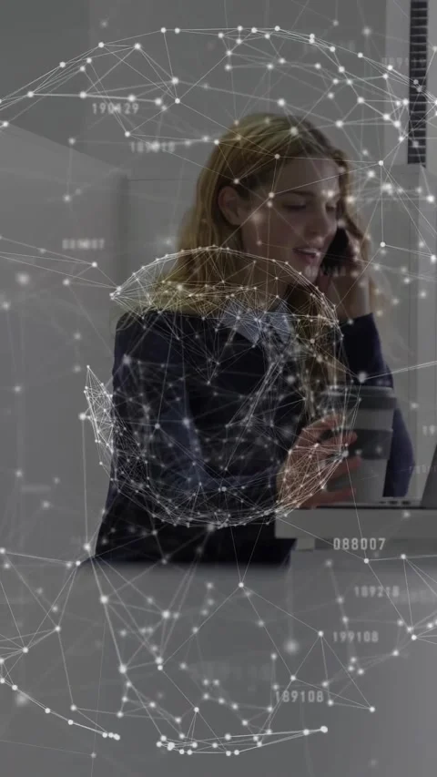 Vertical video: Pullback showing office worker sipping, calling and typing, data Stock Footage 331050349