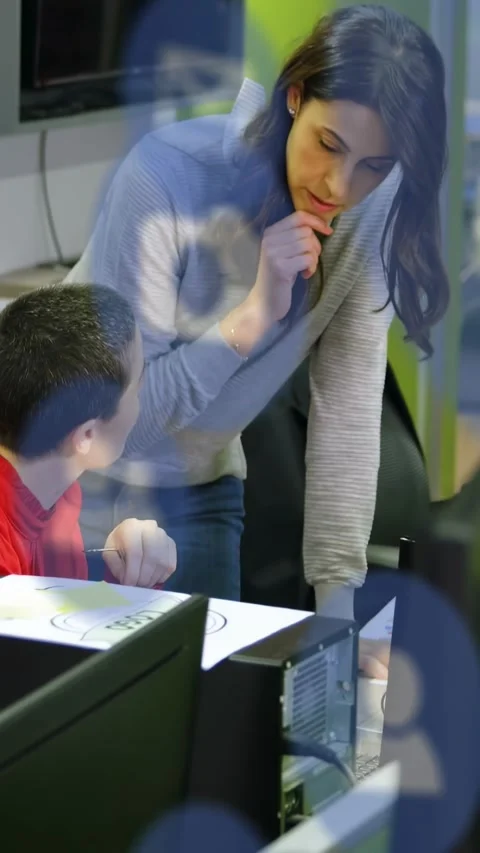 Vertical video: Pupil looking up, teacher leaning over desk guiding sheet by PC Stock Footage 334541271