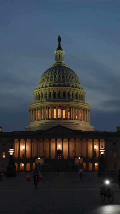 Vertical video push in to the US Capitol with lights and flags waving in Stock Footage 314658106