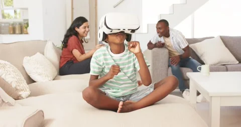 Vertical video: Putting on VR headset youth exploring virtual game on couch, Video stock 344254542