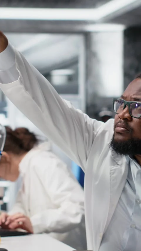 Vertical video Quality control analyst in lab testing blood sample using Stock Footage 319506513