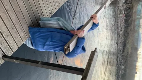Vertical video. Railing breaks and the man falls into the water. Fail. Stock Footage 224845673