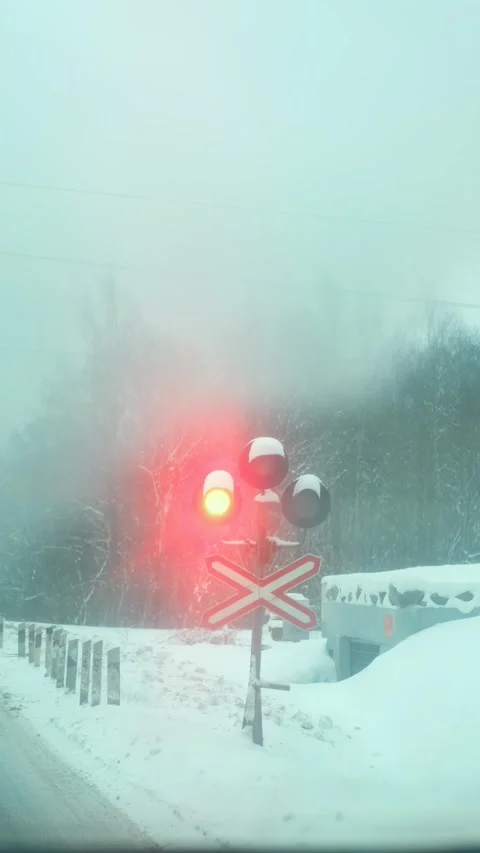 Vertical video, railway traffic light flashes red on a snowy road Stock Footage 296125104