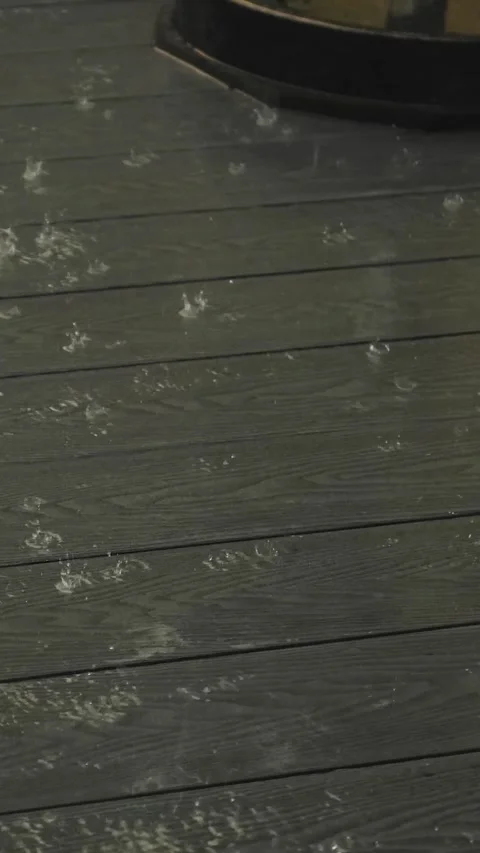 Vertical video. rain-dappled cafe terrace wooden floor close-up of sudden Stock Footage 322051216