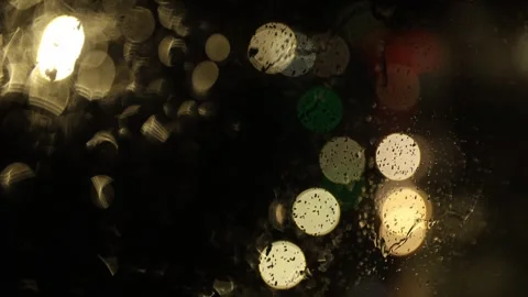 Vertical video. Raindrops on car windshield. Blurred background of headlights . Video stock 265023324