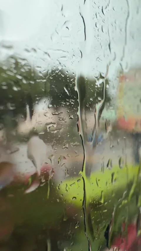 Vertical video of raindrops sliding down a bus window with vegetation and roadsi Stock Footage 341408584