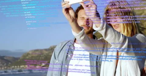 Vertical video: Raising white device, couple in cardigan shirt capturing coast 写真素材