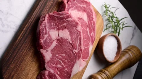 Vertical video, raw ribeye steak beef on white marble background Stock Footage 260963566