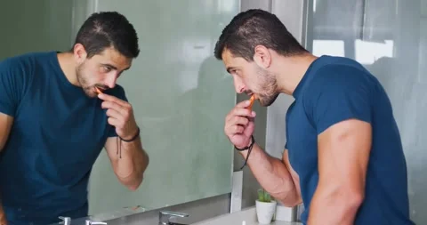 Vertical video: Reaching sink at home, man lifting orange toothbrush and Stock Footage 340457166