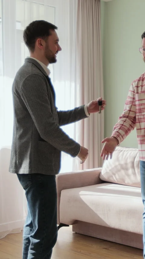 Vertical video Real estate agent is giving keys to buyers of new apartment Stock Footage 340082644