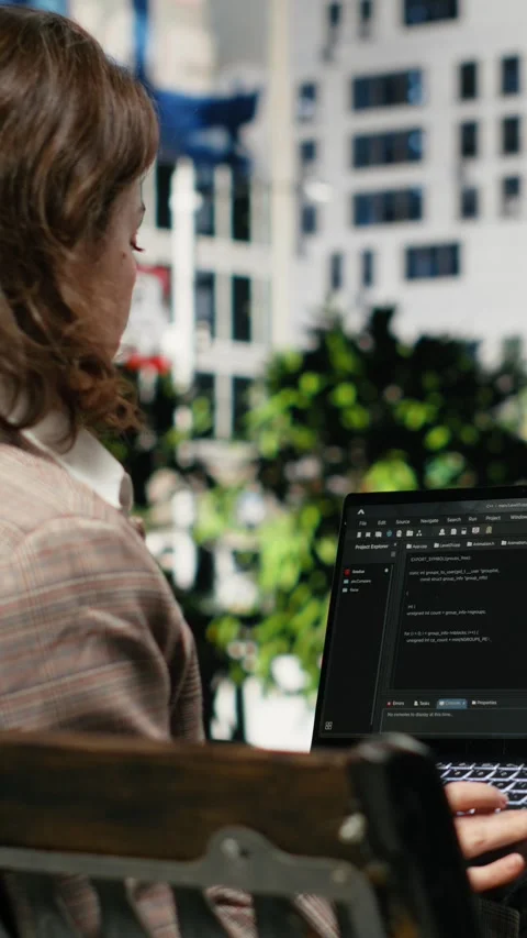 Vertical video Rear view of female programmer on park bench writing code on Video stock 343560681