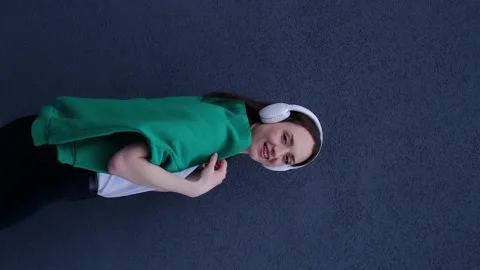 Vertical video rear view of a happy girl dancing and listening to audio in headp 스톡 동영상 239065883