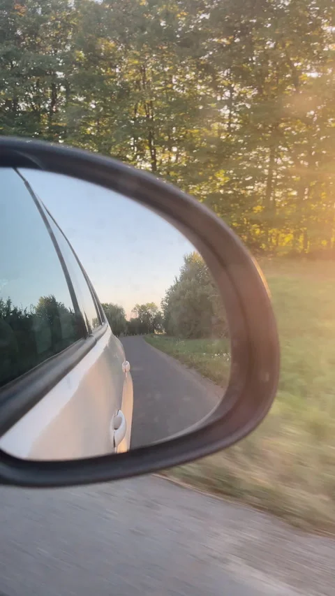 Vertical video of rear view side mirror of automobile car while driving road Stock Footage 285299423