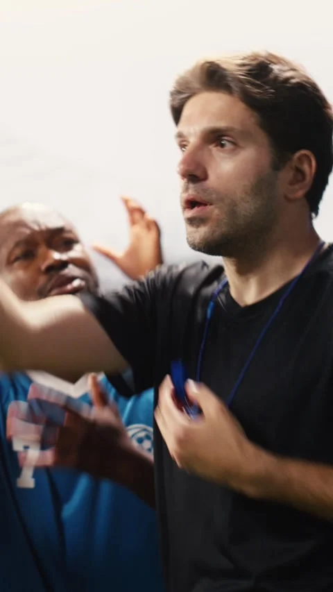 Vertical Video Red card held by football referee with players protesting Stock Footage 338047620