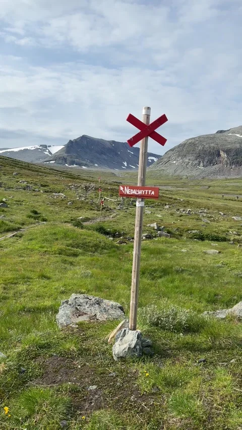 Vertical video of red cross trail sign standing in mountain hiking area Stock Footage 315358558