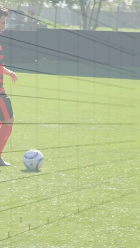 Vertical video: Red soccer player taking ball to keep control dribbling on turf Stock Footage 330273197