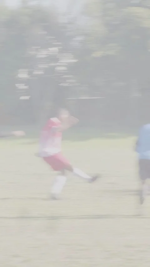 Vertical video: Red striker placing ball by goal, defenders backing to net, ref Stock Footage 333304027