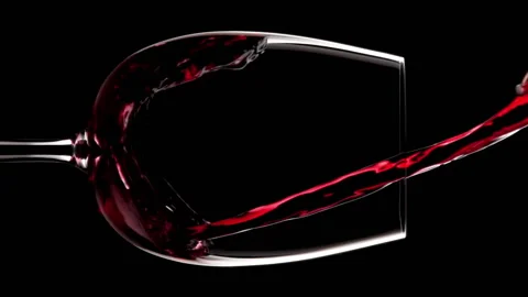 Vertical video of red wine pouring into oversized wine glass on dark background Stock Footage 204786982