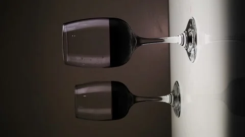 Vertical video. Red wine, in two glasses on a table against a dark background. Stock Footage 146640868
