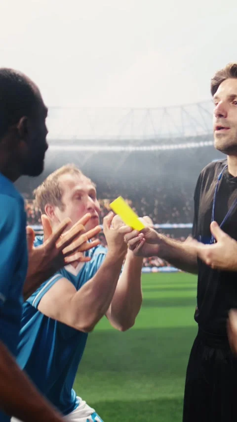 Vertical Video Referee blowing whistle and showing yellow card toward protesting Stock Footage 338046850
