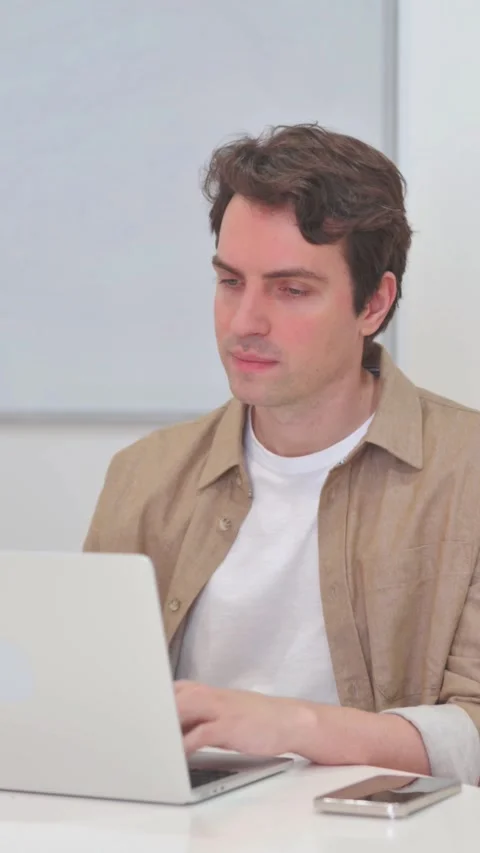 Vertical Video, Rejecting Young Man in Denial while Working on Laptop Video stock 318048117