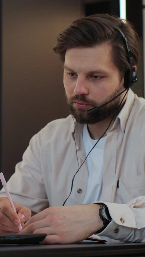 Vertical video. Remote work man at desk with computer, typing and conversation Stock Footage 347779217