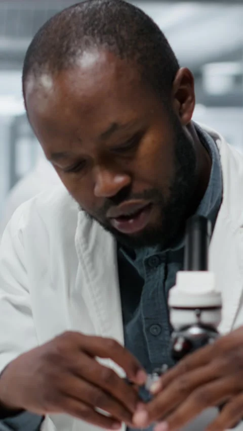 Vertical video Researcher analyzing genetic samples with high tech microscopic Video stock 327243624