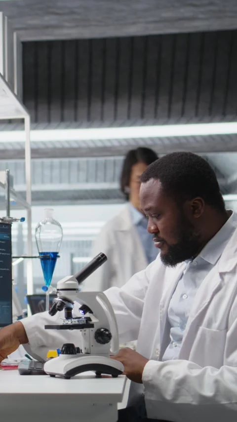 Vertical video Researcher operating compound microscope, doing sample Stock Footage 319720638