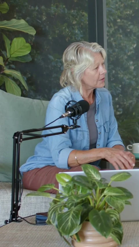 Vertical video: Responding to co-host talking, woman in blue shirt adjusting Stock Footage 348369652