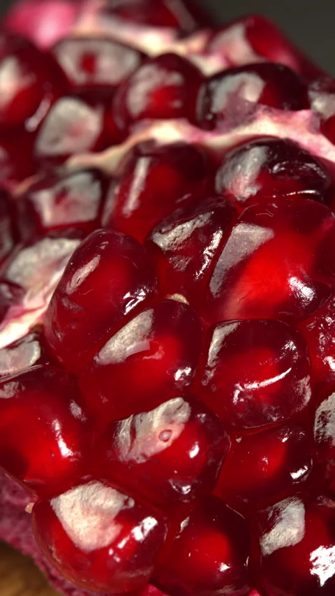 Vertical video Ripe ruby pomegranate close up rotates on black background. Fresh 스톡 동영상 307811818