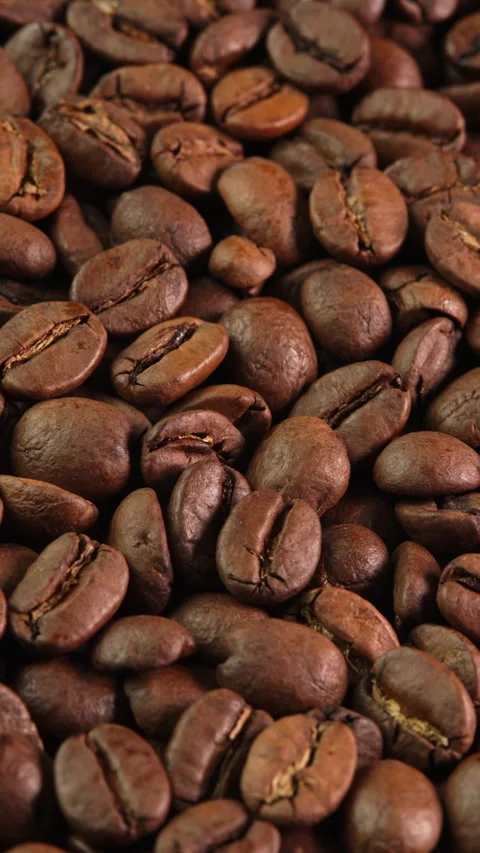Vertical video roasted coffee beans rotating as background close-up macro top Stock Footage 308327915