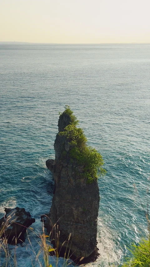 Vertical video. Rock Sea Stack Rising From Turquoise Ocean Near Korawa Beach Wit Stock Footage 337021820
