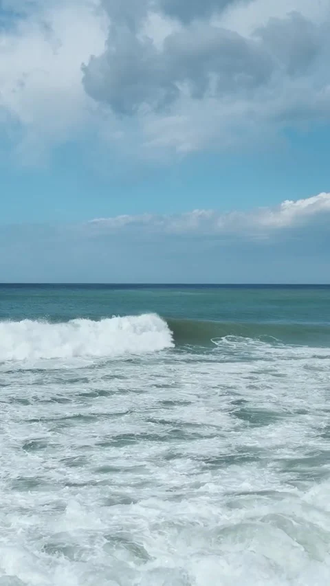 Vertical Video of Rolling Waves Under Pier With Beach Umbrellas at Waterfront Stock Footage 342302613